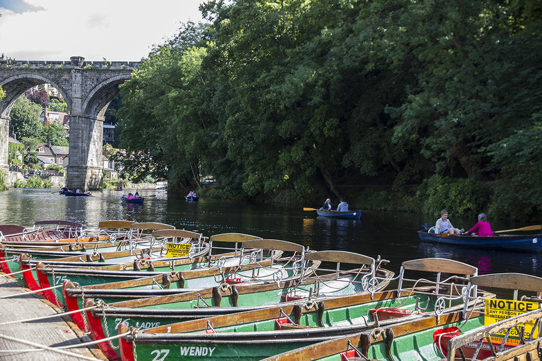 This photo was taken from the waterfront at Knaresborough. In the background is the Knaresborough viaduct with people in the rentable rowing boats below.